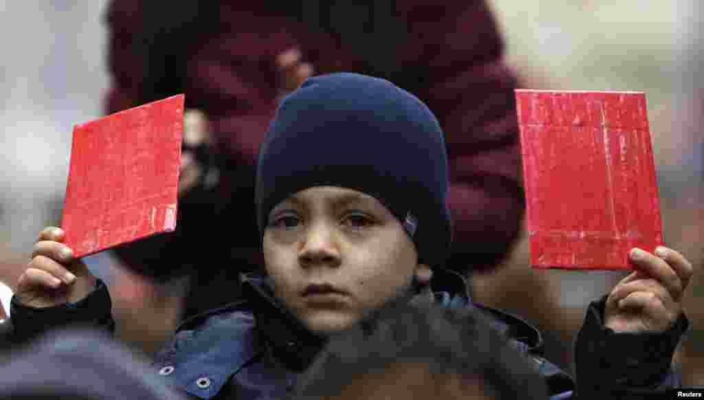 A small child also held aloft a homemade red card, as some protesters said it was time for Zeman to step down. Zeman was elected in 2013 to a four-year term.