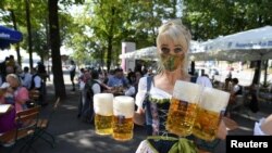 Një grua duke mbajtur në duar birra afër zonës ku do të duhej të organizohej Oktoberfest. Shtator 2020.