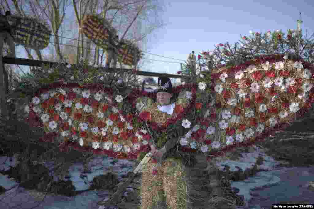 Local men wearing costumes made of hay and reeds march during the celebration of the winter holiday Malanka in the village of Krasnoilsk in western Ukraine. During two days of celebration, locals, young and old, wear traditional masks and carnival costumes and stroll from house to house singing carols, wishing households good luck, while at the same time playing pranks or performing short plays. (epa-EFE/Markiian Lyseiko)