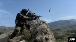 An Afghan security force personnel fires during an ongoing operation against IS militants in the Achin district of Nangarhar Province on April 11.