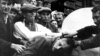 In an undated photo taken during World War II, a Jewish man in western Ukraine is attacked by a mob next to a bust of Lenin. 