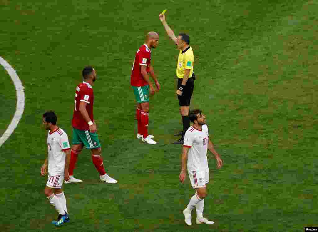 Soccer Football - World Cup - Group B - Morocco vs Iran - Saint Petersburg Stadium, Saint Petersburg, Russia - June 15, 2018 Morocco's Karim El Ahmadi is shown a yellow card by referee Cuneyt Cakir REUTERS/Lee Smith