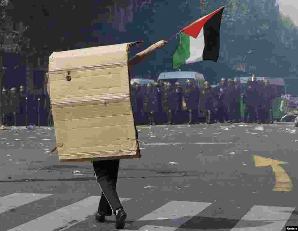 A pro-Palestinian protester in Paris confonts riot police during during a demonstration on July 19 against violence in the Gaza Strip which had been banned by the authorities. (Reuters/Philippe Wojazer)