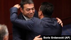 Macedonian Foreign Minister Nikola Dimitrov (left) and Prime Minister Zoran Zeav congratulate each other after the Macedonian parliament first ratified the deal in Skopje on June 20.