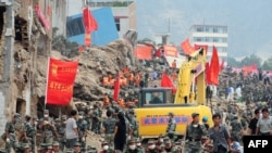 Chinese military personnel help with rescue and cleanup operations amid the rubble of landslide devastation in Zhouqu on August 11.