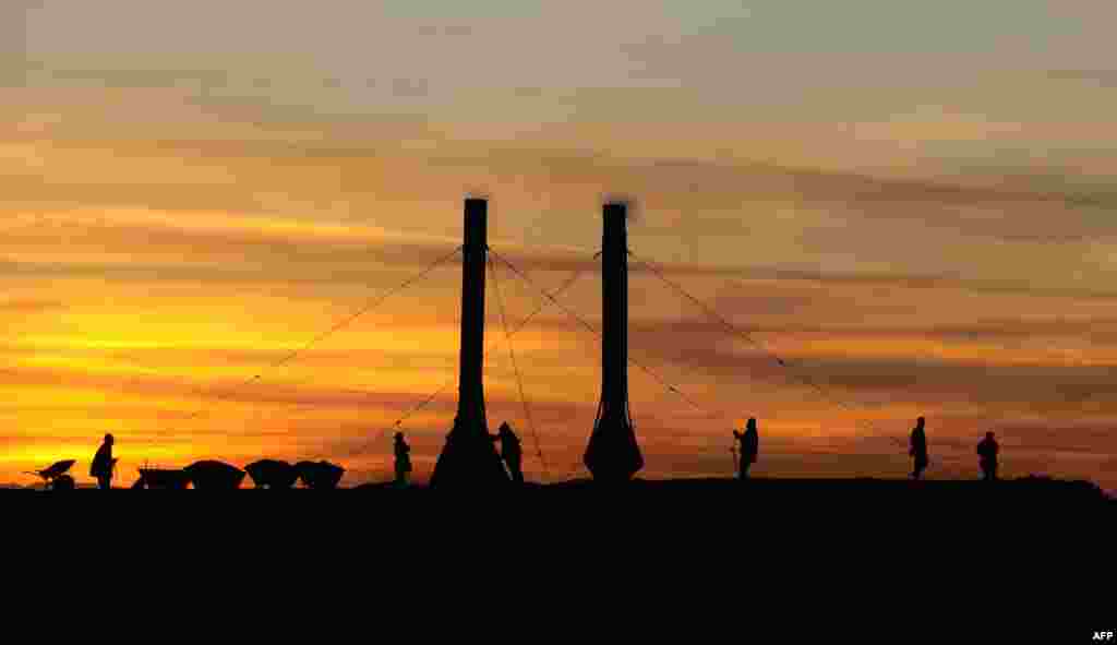 Laborers add coal to the fire and adjust smokestacks in a traditional Afghan brick factory near Mazar-e Sharif. (AFP/Qais Usyan)
