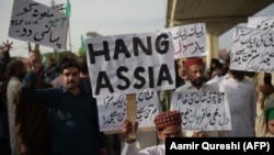 Supporters of Tehrik-e Labaik Pakistan, a hard-line religious political party, hold placards as they march during a protest in Rawalpindi on October 12.