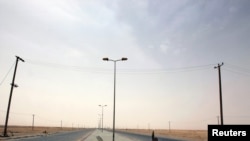 A rebel fighter armed with a rocket-propelled grenade controls an intersection at the western gate of Ajdabiyah on May 3.