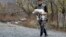 An ethnic Armenian man gathers farm animals as he prepares to leave his house in the village of Chorekdar.