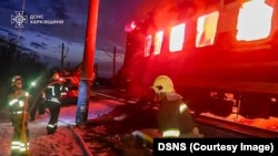 Vatrogasci pokušavaju da ugase požar u putničkom vozu posle smrtonosnog ruskog napada dronom u Harkivskoj oblasti, 27. januar 2026.