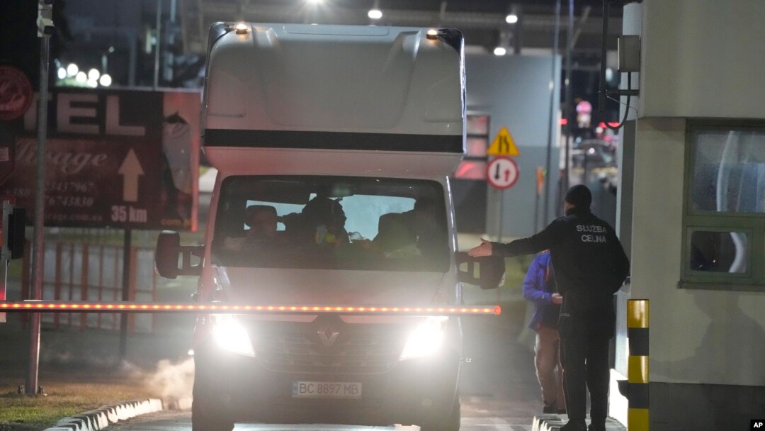 Un ofițer al poliției de frontieră poloneze dirijează mașinile care vin din Ucraina la punctul de trecere a frontierei din Medyka, Polonia, 24 februarie 2022 (imagine de arhivă).