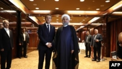 France's president Emmanuel Macron (L) greets Iranian president Hassan Rouhani at the Millennium Hotel near the United Nations on September 18, 2017, in New York.