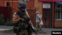 A Ukrainian serviceman patrols in the Russian town of Sudzha, which Kyiv seized control of this month. 