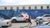 Demonstrant na ulici blizu zgrade EULEX-a u Prištini baca predmet na objekat tokom protesta zbog zatvorskih kazni koje je bivšim liderima OVK izrekao Specijalni sud Kosova u Hagu, 16. septembar 2026.
