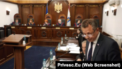 Reprezentantul Parlamentului Găgăuziei, Gheorghi Leiciu (dreapta, în prim-plan) iese la tribuna centrală pentru a prezenta poziția Comratului. Curtea Constituțională, 8 iulie 2026