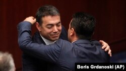 Министерот за надворешни работи Никола Димитров и премиерот Зоран Заев си честитаат по ратификацијата во парламентот 