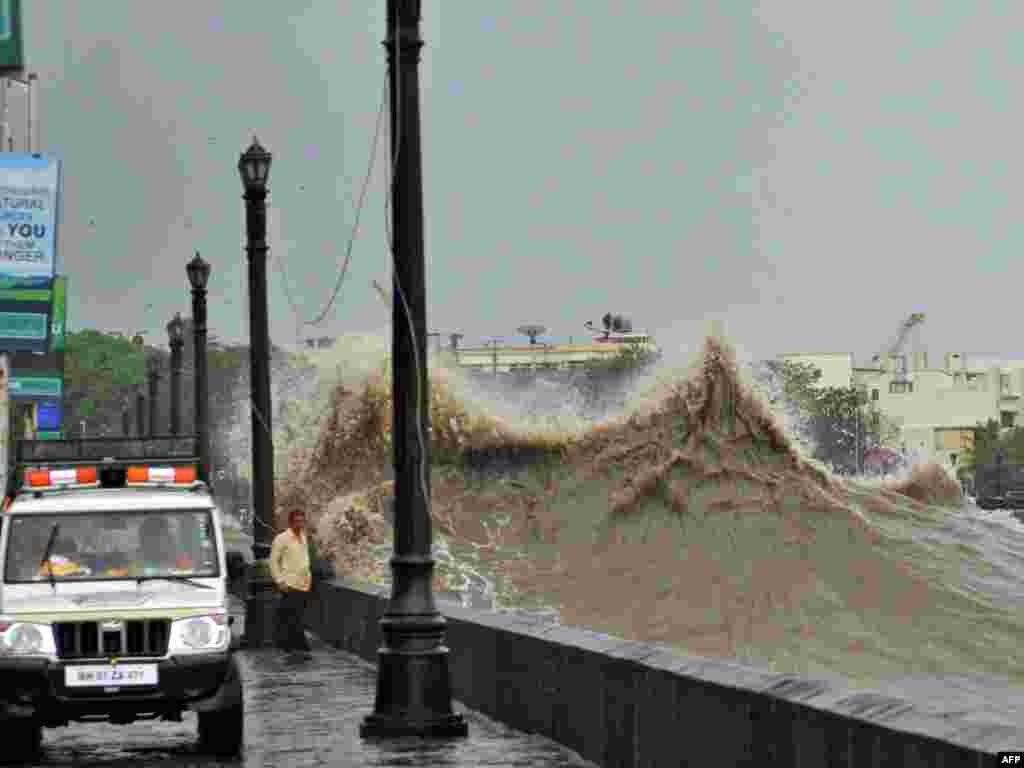 A police vehicle patrols along the promenade as a large wave breaks during high tide near the landmark Gateway of India monument in Mumbai on June 16. The monsoon, which covers most of agriculture-dependent India from June to September, has advanced halfway across the country and is expected to be robust in the current year following a crippling drought in 2009. (AFP)