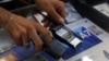 A vendor shows walkie-talkie devices without batteries at an electronic store in Sidon