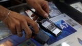 A vendor shows walkie-talkie devices without batteries at an electronic store in Sidon