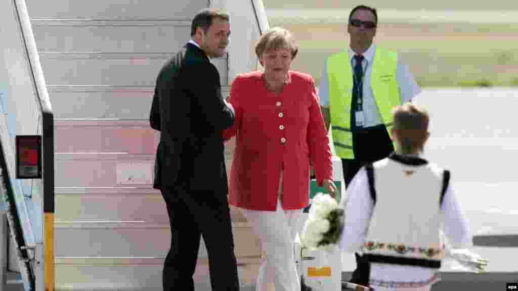 Moldova -- Prime Minister Vlad Filat (L) welcomes  German Chancellor Angela Merkel to Chisinau, 22Aug2012