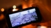 На экране смартфона трансляция канала NEXTA из центра Минска, где в августе, сентябре и октябре проводятся массовые акции против режима Лукашенко
