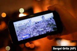 Egy felhasználó a NEXTA élő Telegram-csatornája közvetítését nézi egy minszki demokráciapárti tüntetésről, 2020. augusztus 19-én. A Telegram alkalmazás nélkülözhetetlen eszköze lett a tömegtüntetéseket koordináló belarusz ellenzékieknek. A Koalíció a biztonságos webért nevű amerikai civil szervezet azonban januárban pert indított az App Store ellen, azt követelve, hogy az alkalmazást töröljék a kínálatból. Mindez azután történt, hogy Trump volt amerikai elnök hívei behatoltak a Capitoliumba. A felperes szerint a Telegram „fehér felsőbbrendűségiek, neonácik és mások gyűlöletkeltő tartalmait” közvetíti. Május 24-ig az App Store nem törölte a Telegramot.