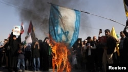 Supporters of the Iranian Islamic republic burn a painted Israeli flag in Tehran on October 2 during a gathering to support the missile attack on Israel the previous day.