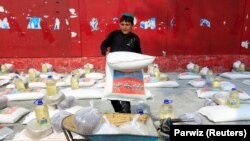 A boy uploads free food donated by the Afghan government, on a cart amid the spread of the coronavirus disease (COVID-19), in the eastern city of Jalalabad on April 28.