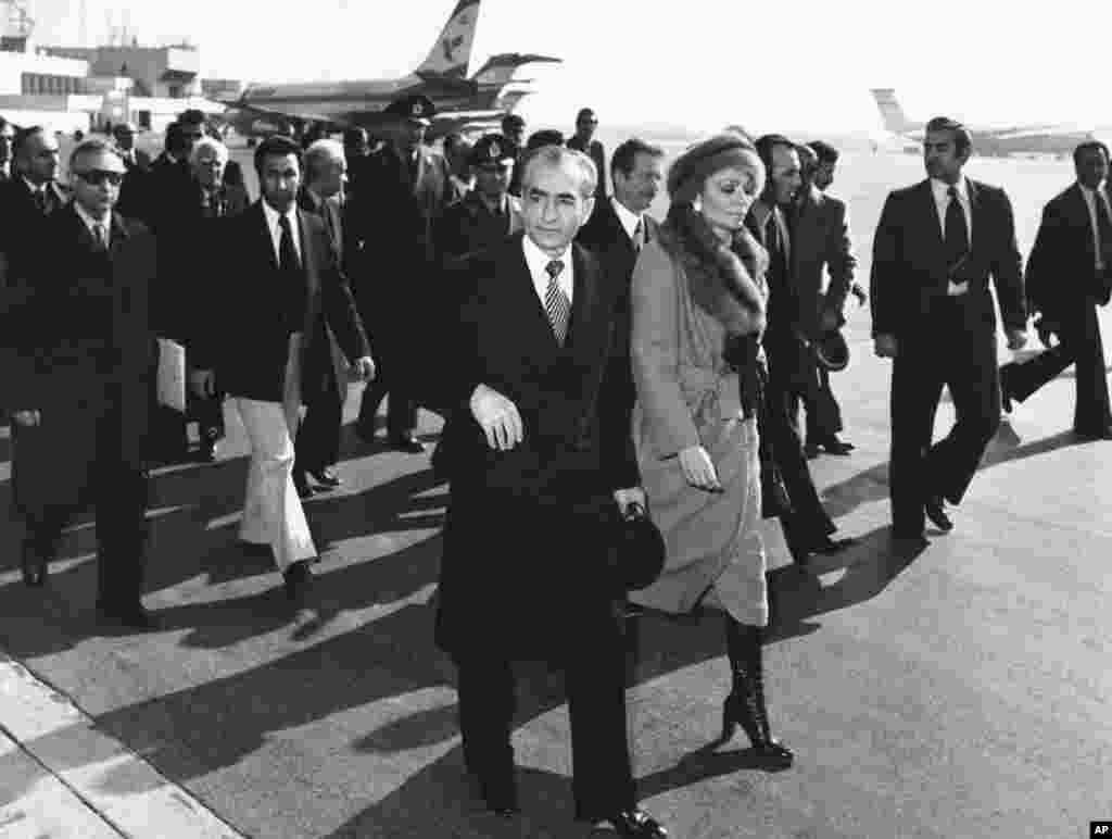 Iran's Shah, Mohammad Reza Pahlavi, and his wife, Empress Farah, walk on the tarmac at Mehrabad Airport in Tehran to board a plane on January 16, 1979. The Shah left Iran for what was officially a vacation. Many Iranians rejoiced with chants of "The Shah is gone!" The man who had ruled the country for 37 years would never return from exile, dying some 13 months later.