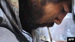 An addict smokes heroin in an abandoned building in Kabul. (file photo)