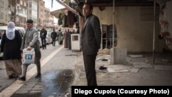 Faruk Taylan stands inside his damaged store, where he once sold shoes and clothes in the Sur district of Diyarbakir.