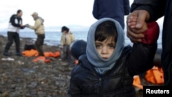 Greece -- A Syrian refugee child looks on, moments after arriving on a raft with other Syrian refugees on a beach on the Greek island of Lesbos, January 4, 2016