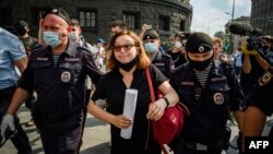 Russian police officers in Moscow detain a supporter of Ivan Safronov, a former journalist who was detained on "treason" charges earlier this week.