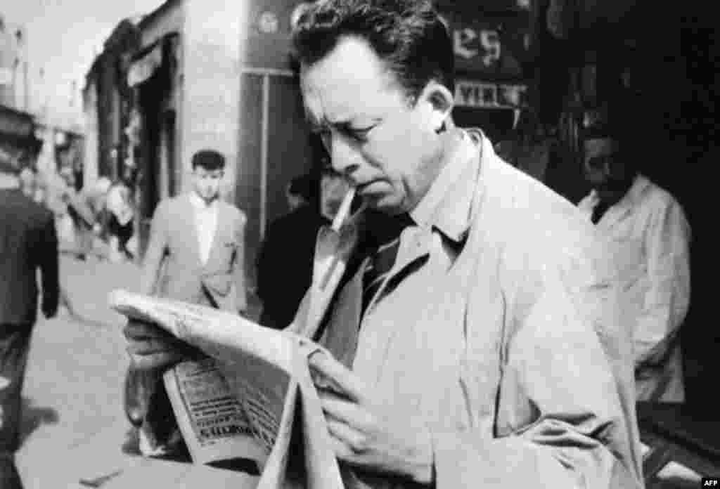آلبر کامو در حال خواندن روزنامه در یکی از خیابان&zwnj;های پاریس- سال ۱۹۵۹