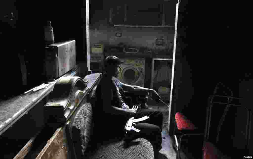 A member of the Free Syrian Army sits with his weapon inside a house in Aleppo&#39;s al-Sayyid Ali neighborhood. (Reuters/Muzaffar Salman)