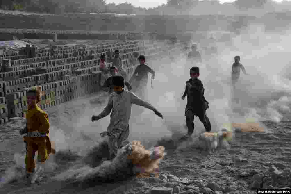 Afghan children play along a dusty road on the outskirts of Jalalabad. (AFP/Noorullah Shirzada)