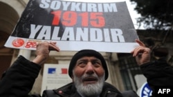 Turkey - A Turkish man holds a placard reading "Genocide is a lie" in front of the French Consulate in Istanbul to protest against a law, voted the day before by French MPs, that outlaw denial of the 1915 Armenian genocide in Ottoman Turkey, 23Dec2011