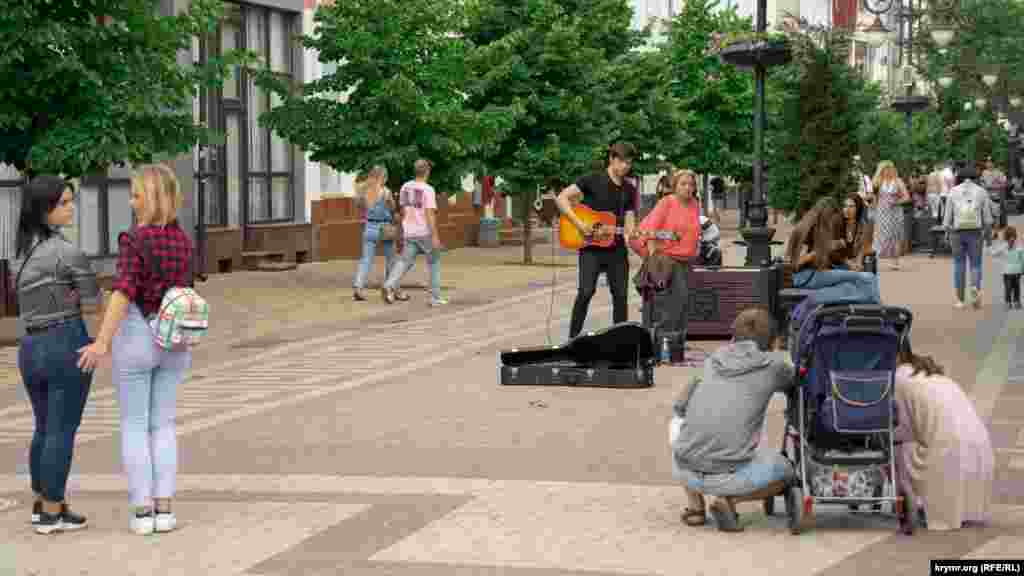 Вуличний гітарист розважає перехожих на вулиці Пушкіна