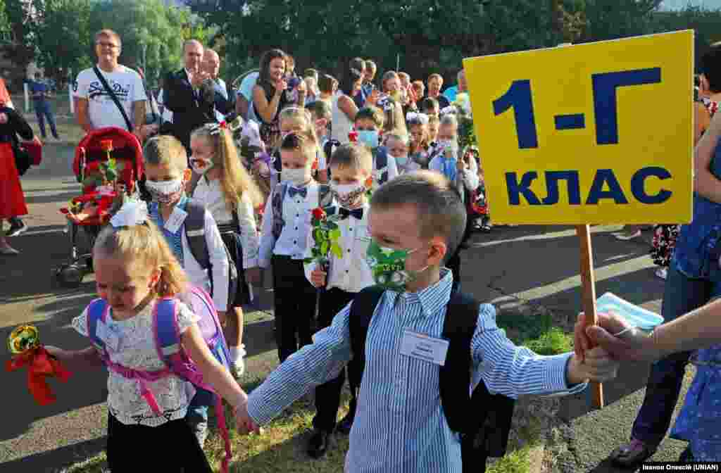 Першокласники у захисних масках біля будівлі школи в День знань у столиці України, 1 вересня 2020 року. Цього дня за парти у Києві сіли більш як 30 тисяч першокласників