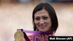 Atleta Natalia Antiuh arătând medalia de aur câștigată la Olimpiada de vară din Londra, 9 august 2012