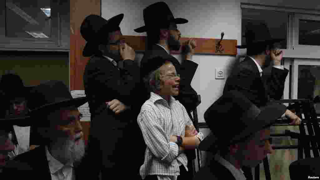 Relatives of Rabbi Yosef Shalom Elyashiv mourn before his funeral procession in Jerusalem's Mea Shearim neighborhood on July 18. (REUTERS/Baz Ratner)