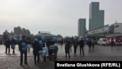 Люди на народных гуляньях по случаю празднования Наурыза с голубыми шарами в руках. Астана, 22 марта 2018 года.