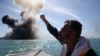Iran -- A member of Iran's elite Revolutionary Guards chants slogans after attacking a naval vessel during a military drill in the Strait of Hormuz in southern Iran, February 25, 2015