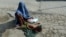 انځور له ارشیف څخه: په کابل کې یوه سوالګره مېرمن د سړک پر غاړه د خیر غوښتلو لپاره لاس غځوي، په داسې حال کې چې ماشوم يې ورسره پر سړک پروت دی.
