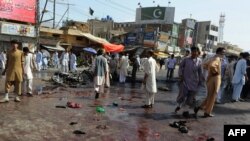 Shi'ite men gather at the site of the attack in Quetta.