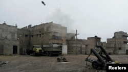 Free Syrian Army fighters fire a homemade mortar at Karm al-Tarab neighborhood in Aleppo on January 27.