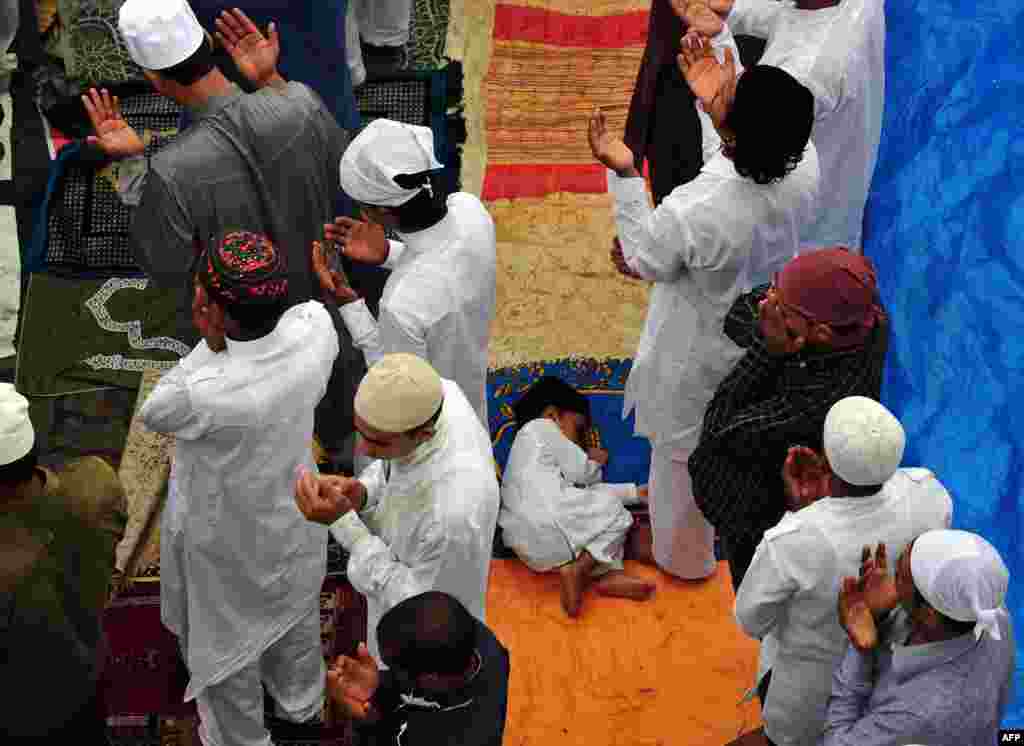 A child sleeps between rows of Indian Muslims gathered to offer Eid al-Fitr prayers in Mumbai. (AFP/Indranil Mukherjee)