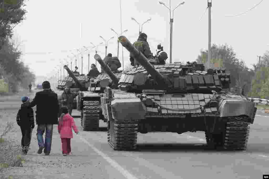 Місцеві жителі проходять повз танкову колону проросійських бойовиків, Луганська область, 20 жовтня 2015 року