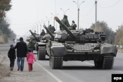 Місцеві жителі проходять повз танкової колони бойовиків угруповання «ЛНР». Луганська область, 20 жовтня 2015 року