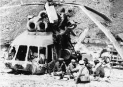 Афганські моджагеди снідають біля уламків збитого ними радянського вертольота